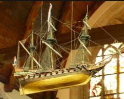 A miniature ship, medieval paintings, and many other admirable things are kept safely in the church.